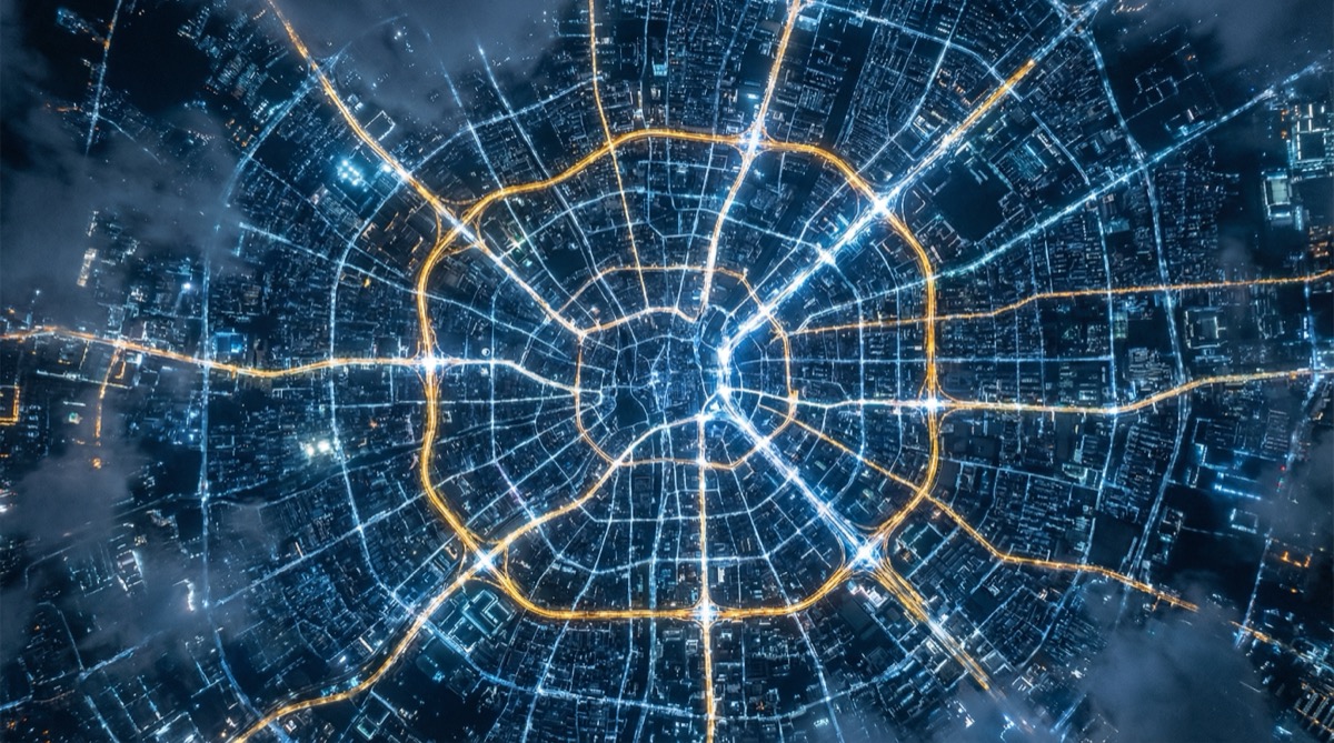 Aerial view of city at night with illuminated routing paths representing Lightning Network pathfinding
